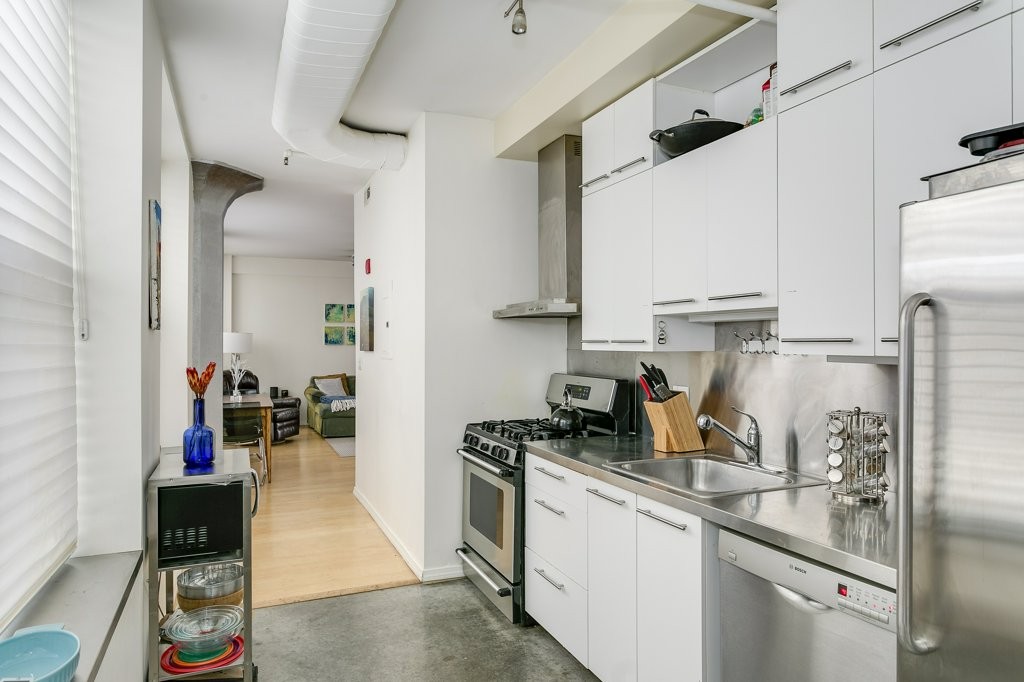 453 Washington Street, Unit 5D Boston, MA 02111 - Photo 15 of 17 a kitchen with a sink appliances and cabinets