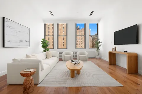 a living room with furniture a flat screen tv and a large window