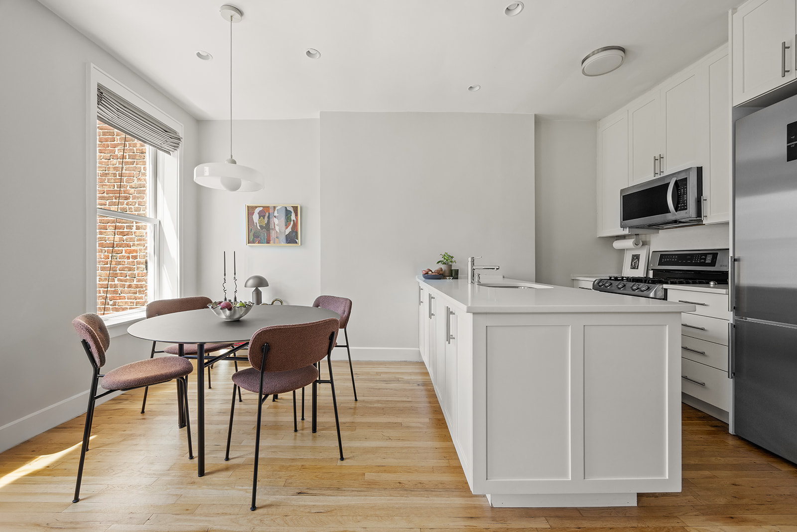 230 Baltic Street, Unit 2 Brooklyn, NY 11201 - Photo 3 of 11 a kitchen with stainless steel appliances granite countertop a kitchen island hardwood floor sink stove dining table and chairs
