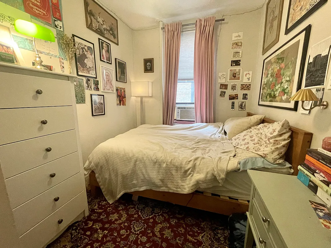 210 Thompson Street, Unit 4DN Manhattan, NY 10012 - Photo 8 of 10 a bedroom with a bed and wooden floor