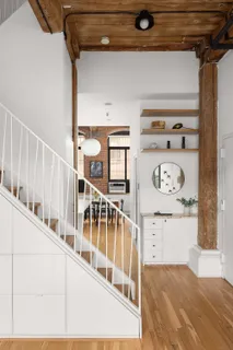 a view of a hallway with white walls and stairs