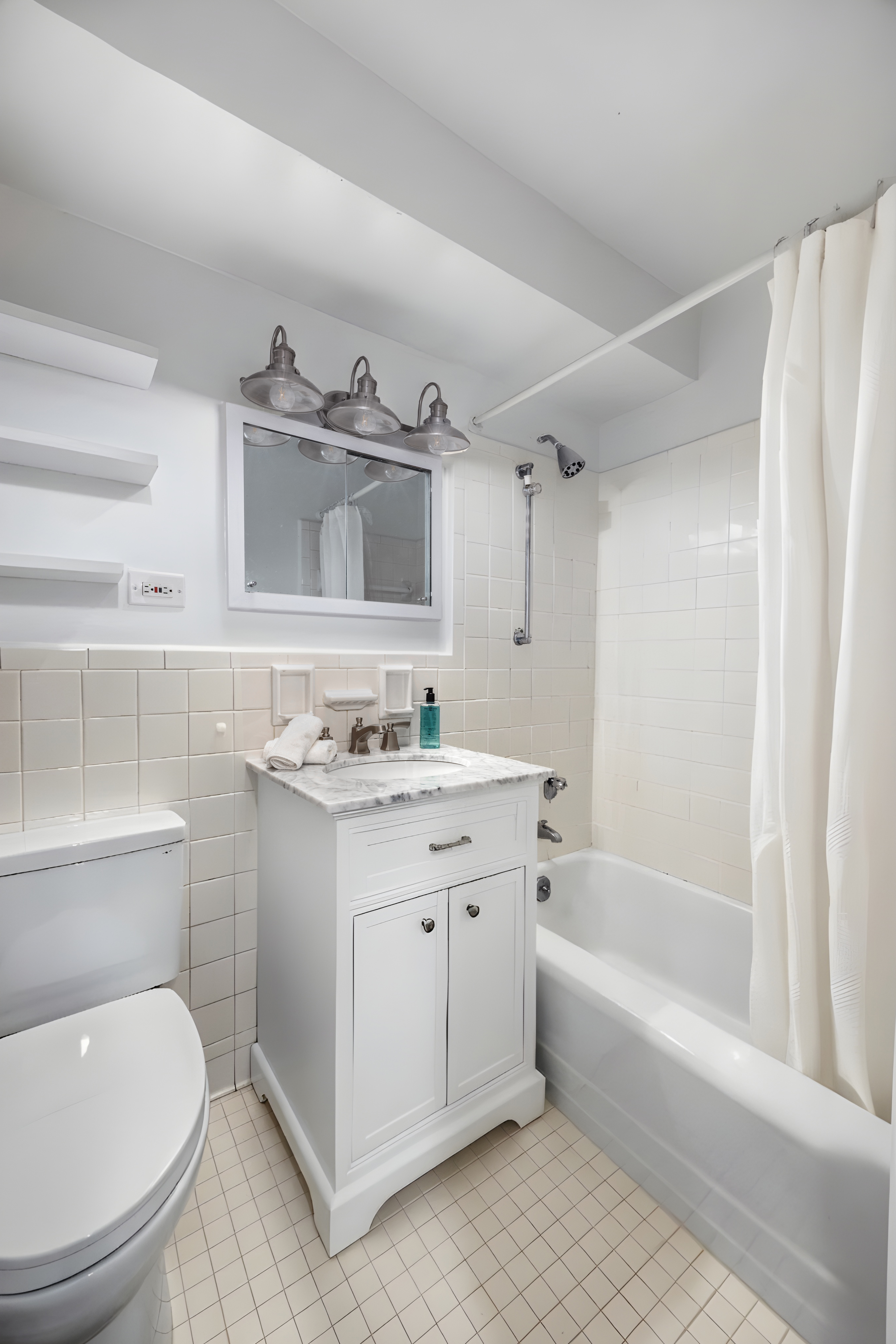 1199 Park Avenue, Unit 3G Manhattan, NY 10128 - Photo 8 of 12 a bathroom with a granite countertop sink a toilet and bathtub