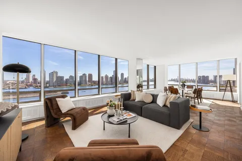 a living room with furniture kitchen view and large windows