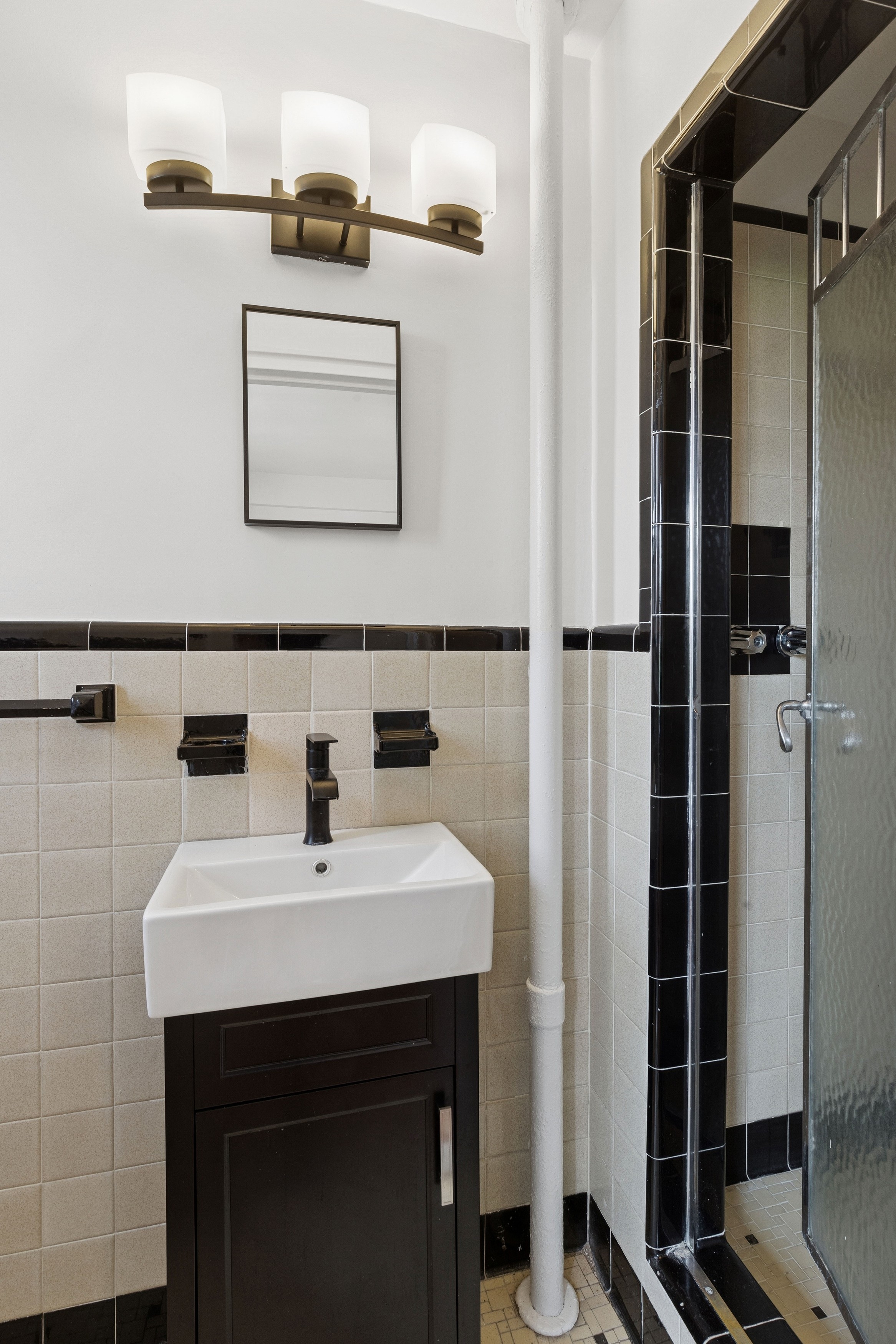 55 Park Terrace East, Unit B74 Manhattan, NY 10034 - Photo 13 of 26 a bathroom with a sink a mirror and shower