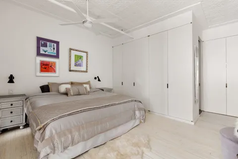 a bedroom with a bed and a painting on the wall