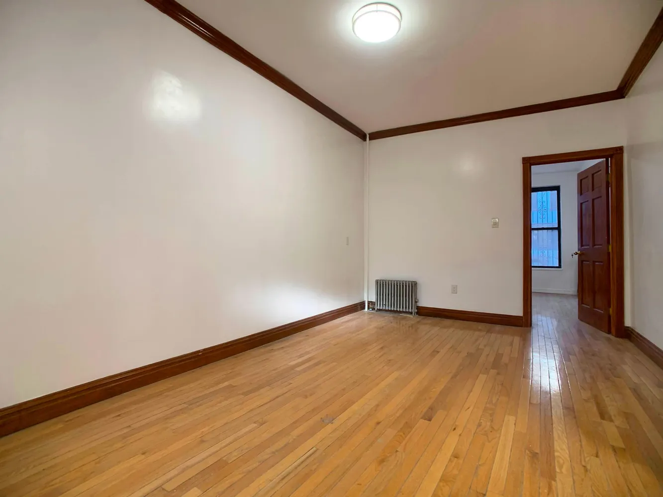 a view of an empty room with wooden floor