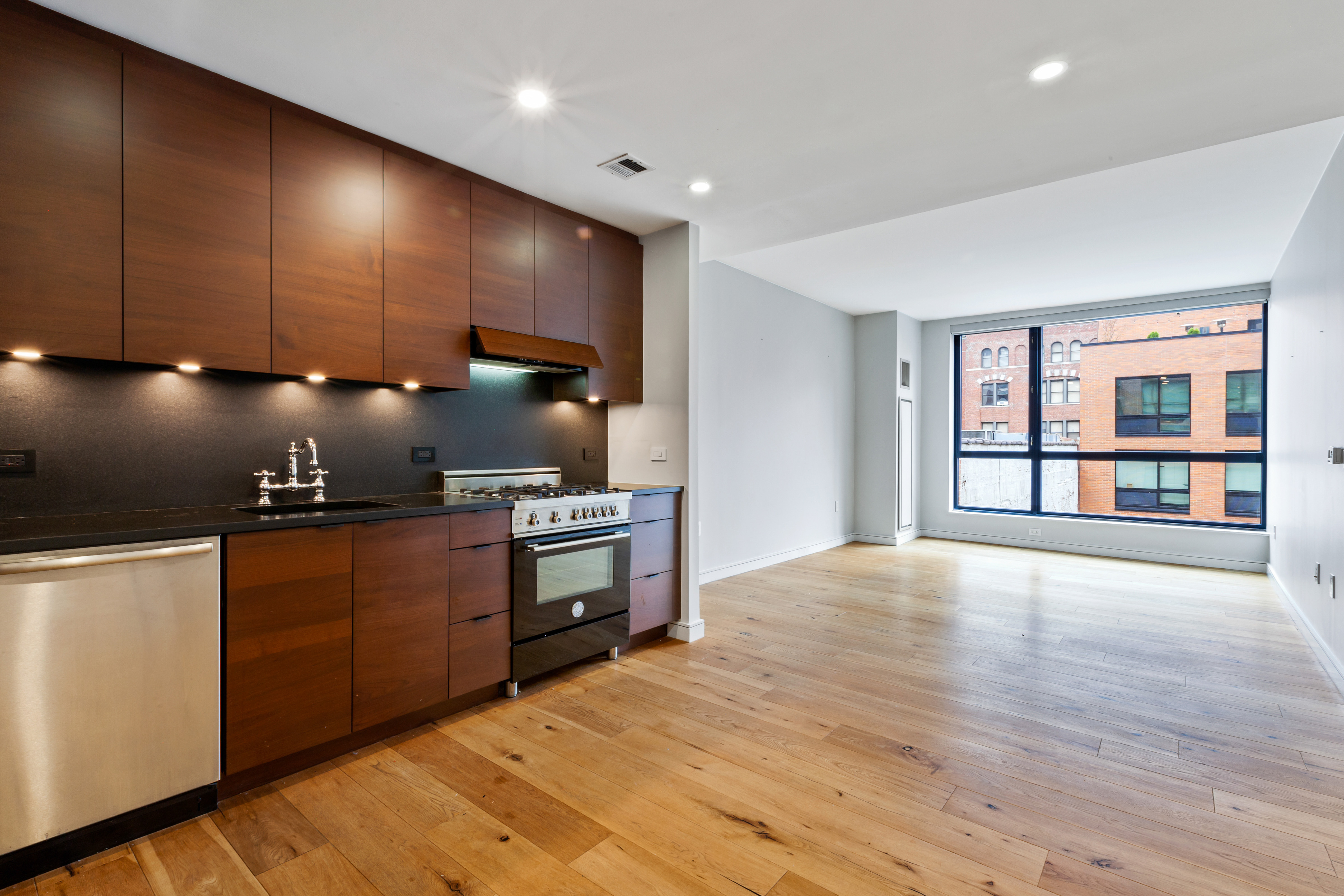 540 West 28th Street, Unit 4F Manhattan, NY 10001 - Photo 2 of 16 a kitchen with stainless steel appliances kitchen island granite countertop a stove a sink and a microwave
