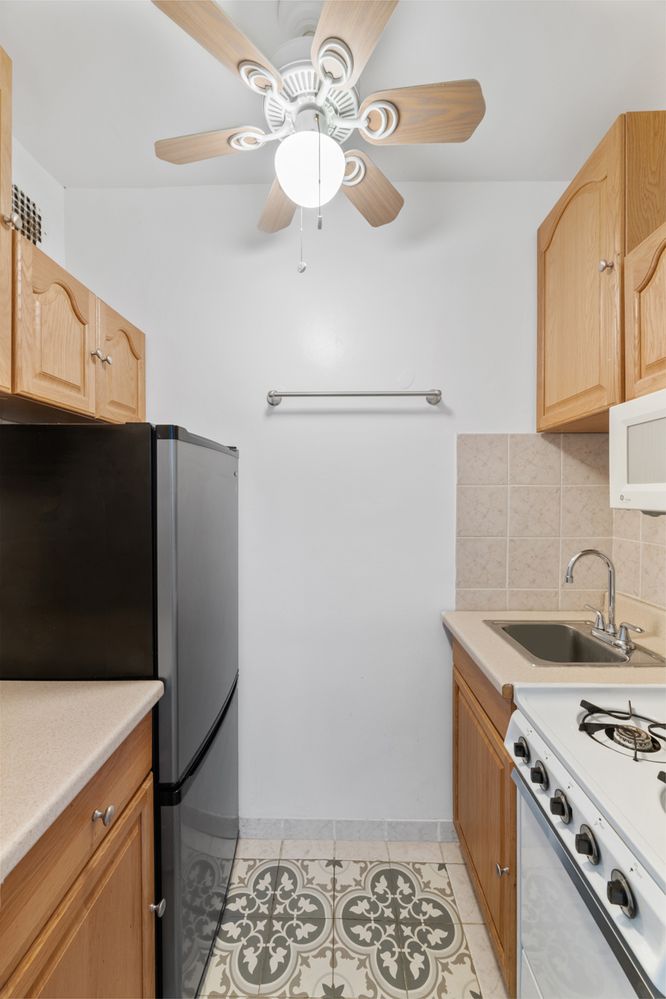 a kitchen with stainless steel appliances granite countertop a sink a stove a refrigerator a washer and dryer