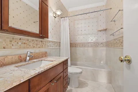 a bathroom with a granite countertop sink a toilet and shower