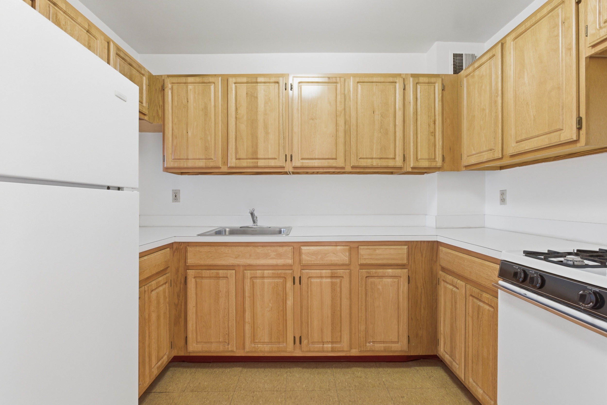20 East 126th Street Manhattan, NY 10035 - Photo 16 of 19 a kitchen with stainless steel appliances granite countertop a sink and a white cabinets