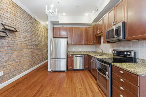 a kitchen with stainless steel appliances granite countertop a stove a refrigerator and a microwave