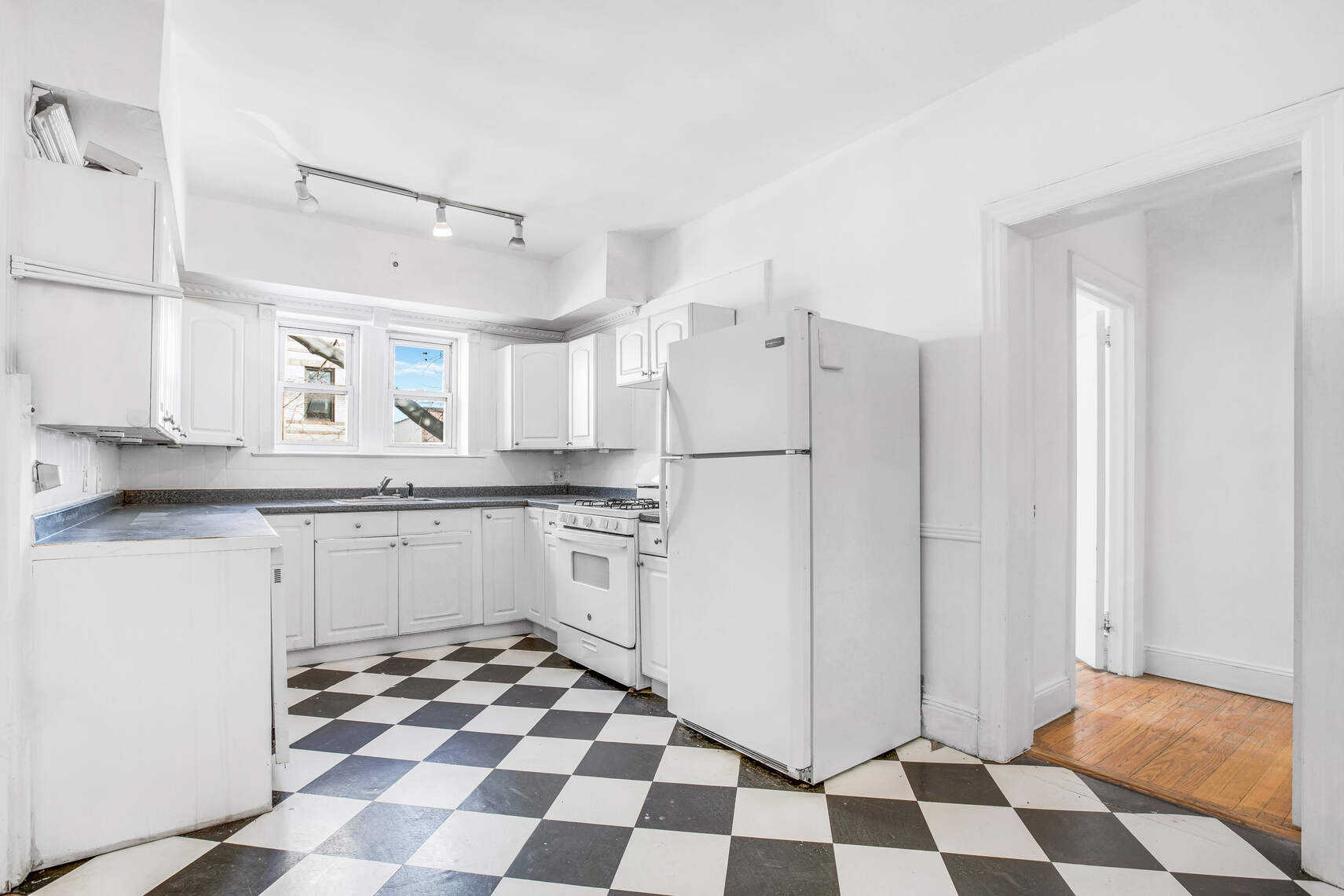 8301 4th Avenue Brooklyn, NY 11209 - Photo 5 of 20 a kitchen with a checkered floor and white cabinets
