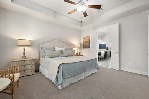 a spacious bedroom with a bed a chandelier and closet