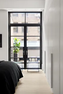 a bedroom with a bed and a large window