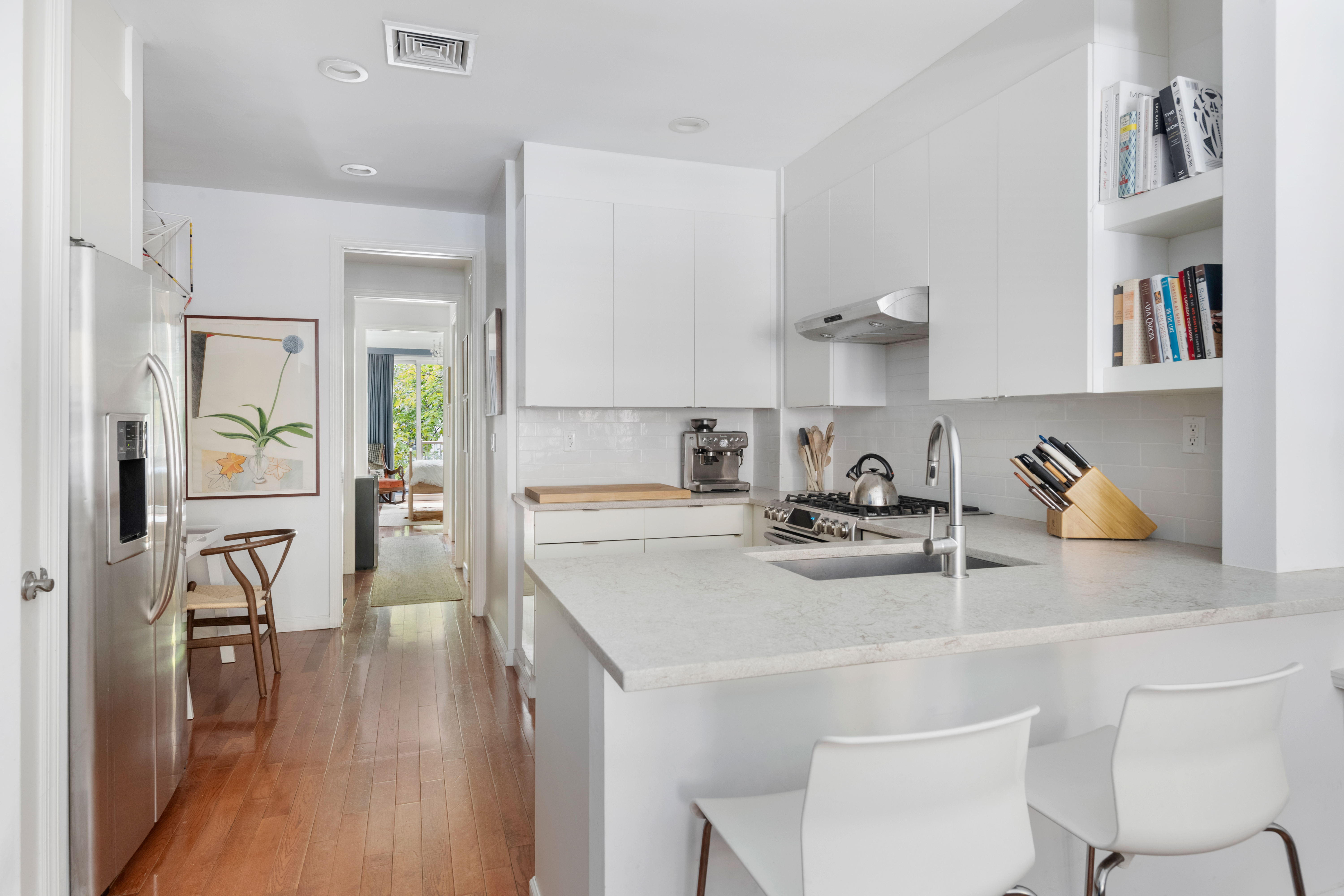 121 West 131st Street, Unit 2 Manhattan, NY 10027 - Photo 4 of 14 a kitchen with a sink a stove and chairs