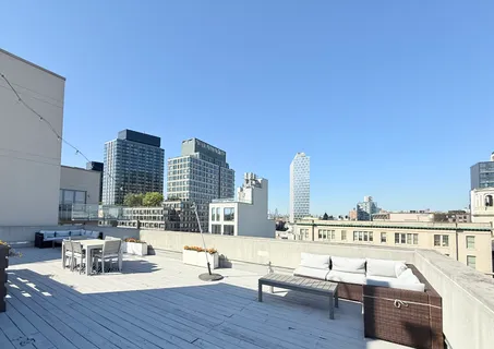 a view of roof deck with seating space and city view
