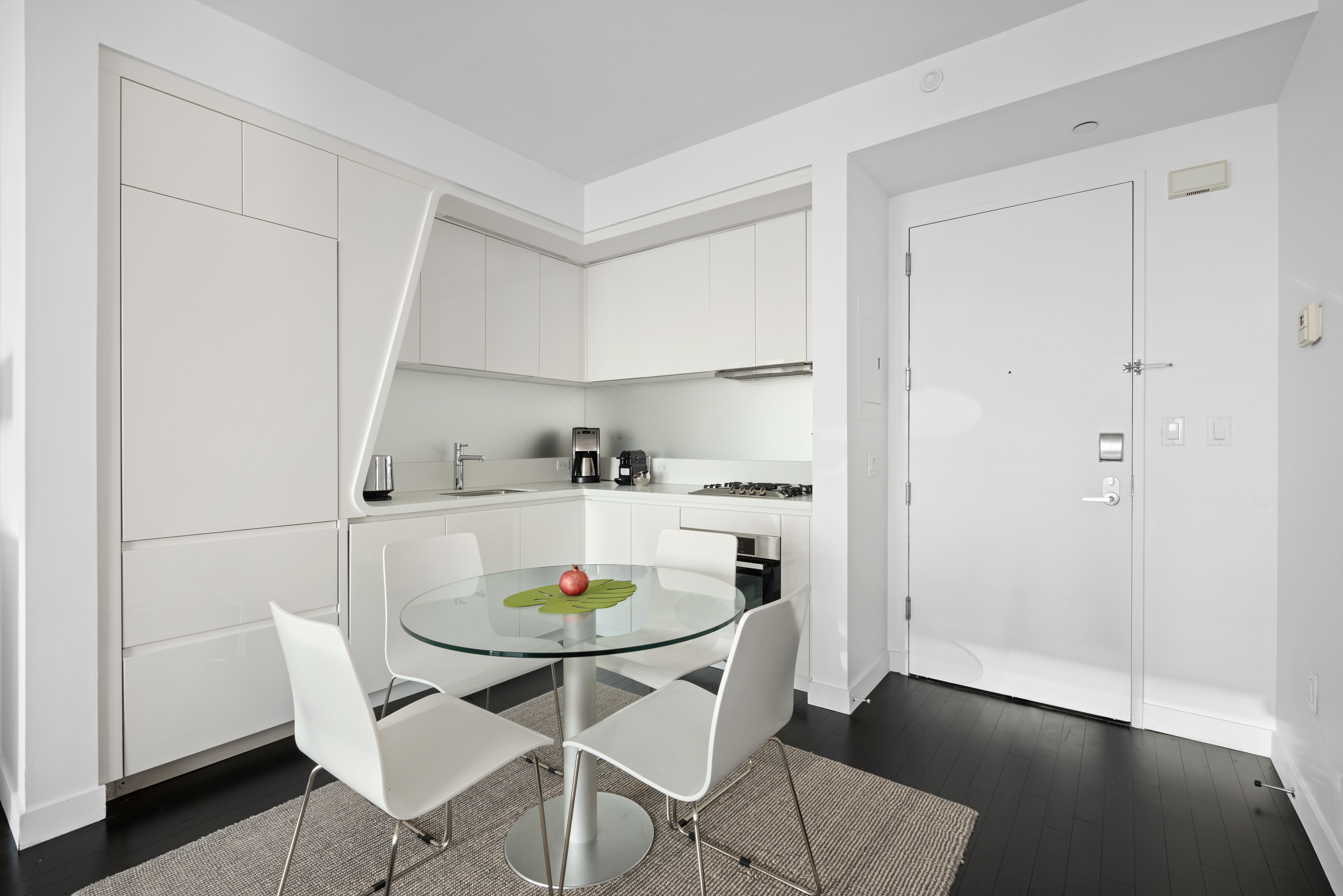 123 Washington Street, Unit 49G Manhattan, NY 10006 - Photo 3 of 11 a kitchen with a dining table and chairs