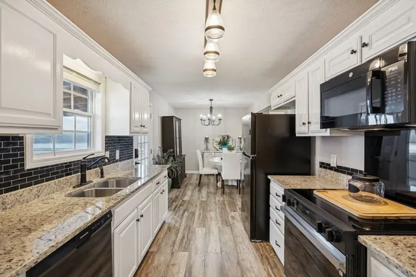 a kitchen with stainless steel appliances a stove sink microwave and refrigerator