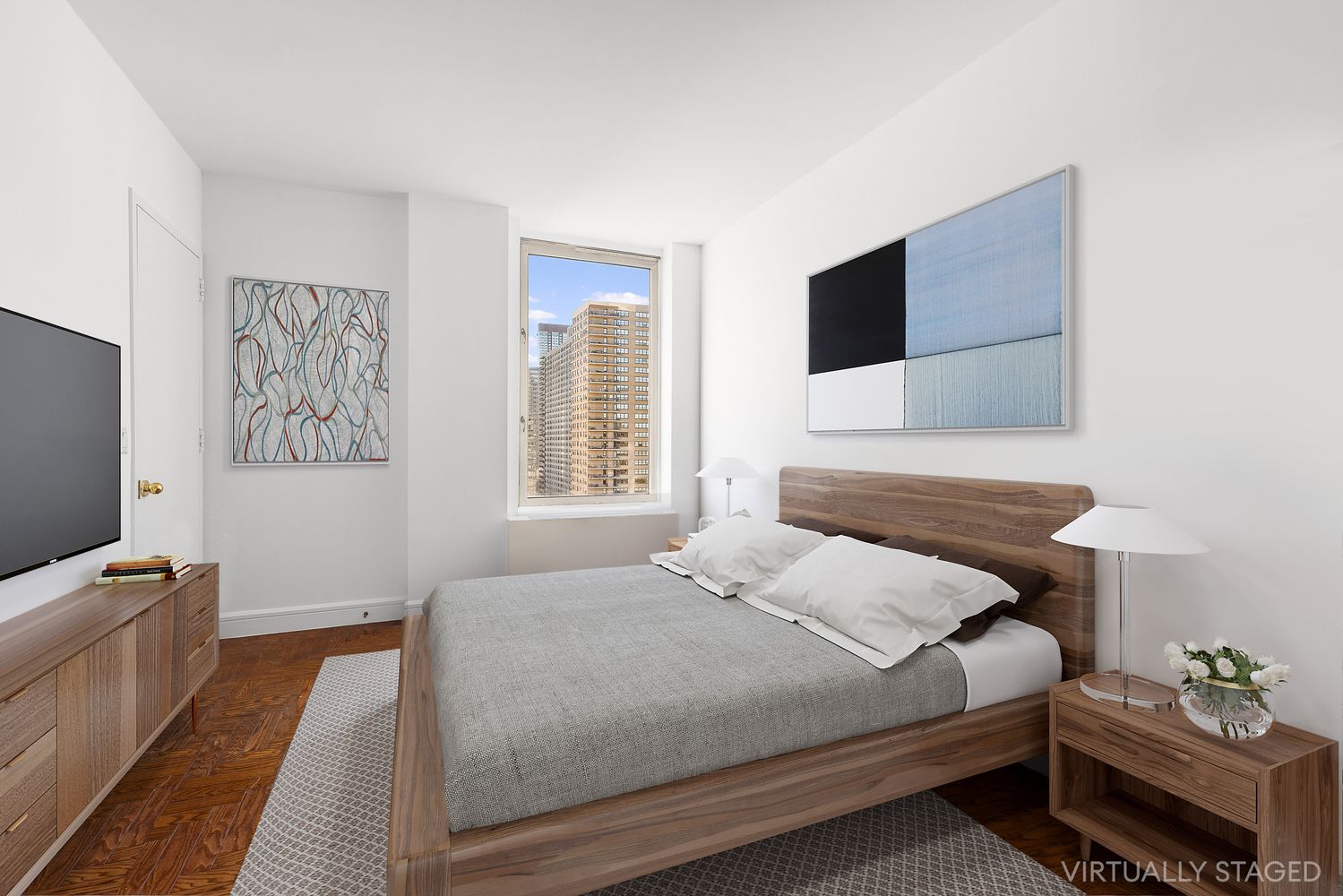 a bedroom with a bed wooden floor and flat screen tv
