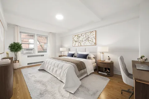 a spacious bedroom with a bed a couch and potted plant on the table