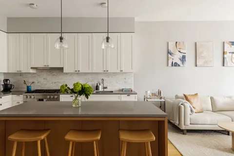 a kitchen with a table chairs and white cabinets