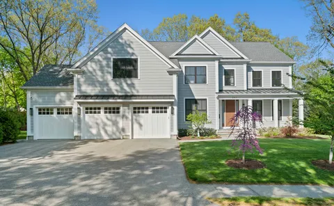 a front view of a house with a yard and potted plants