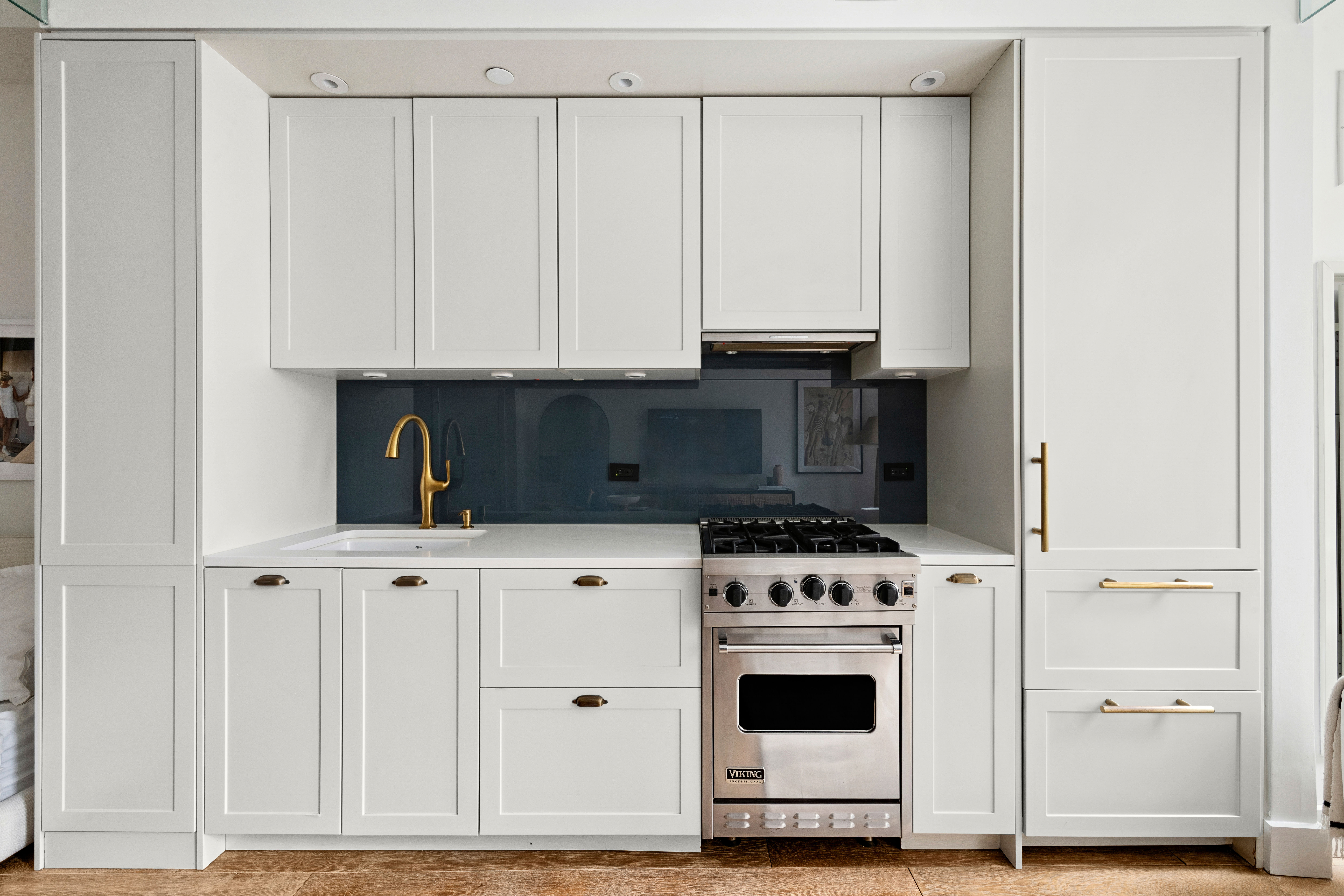 93 Worth Street, Unit 406 Manhattan, NY 10013 - Photo 3 of 11 a kitchen with granite countertop white cabinets and white appliances