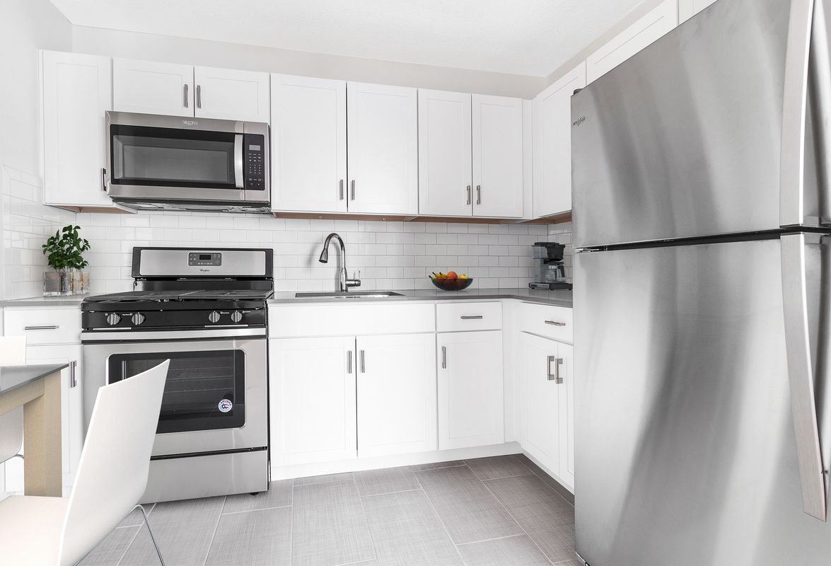 3333 Broadway, Unit E4C Manhattan, NY 10031 - Photo 3 of 23 a kitchen with white cabinets and stainless steel appliances