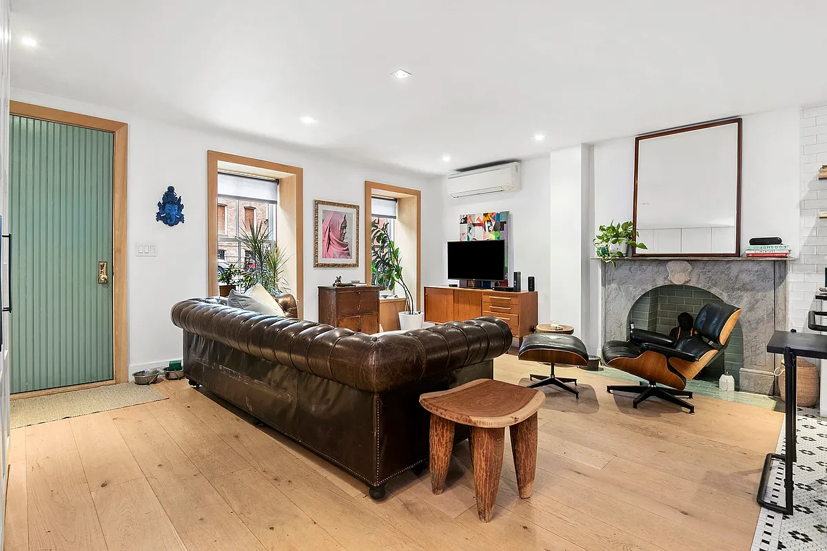 87 Monroe Street, Unit 1 Brooklyn, NY 11216 - Photo 2 of 11 a living room with furniture flat screen tv and a fireplace