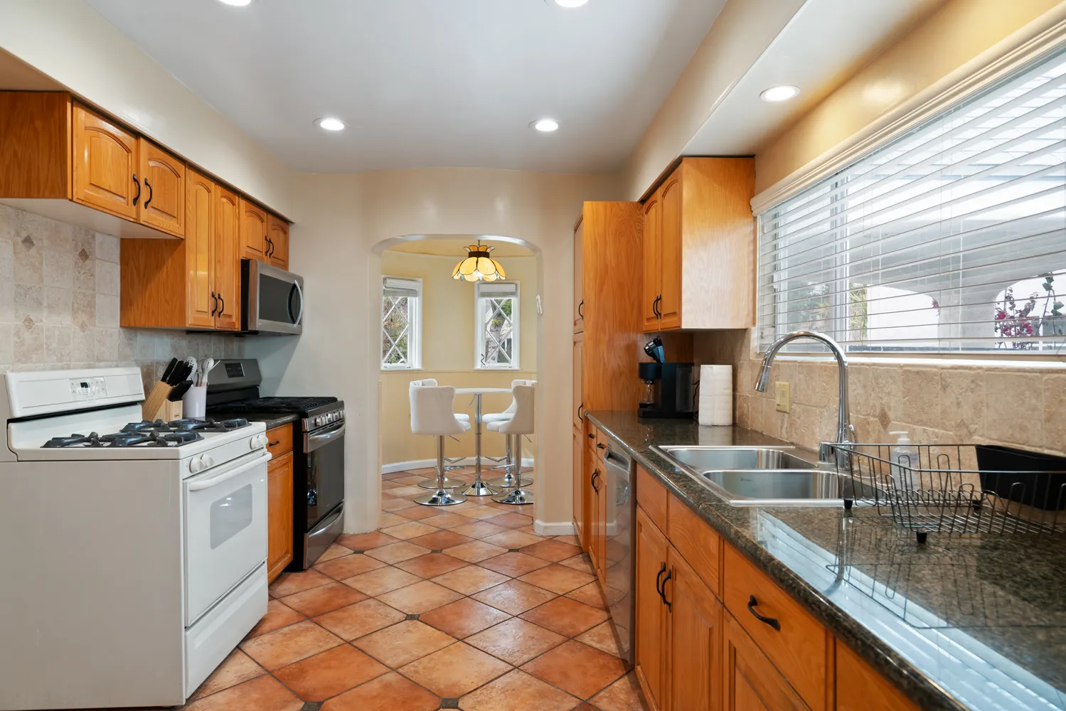 a kitchen with stainless steel appliances granite countertop a sink stove and cabinets