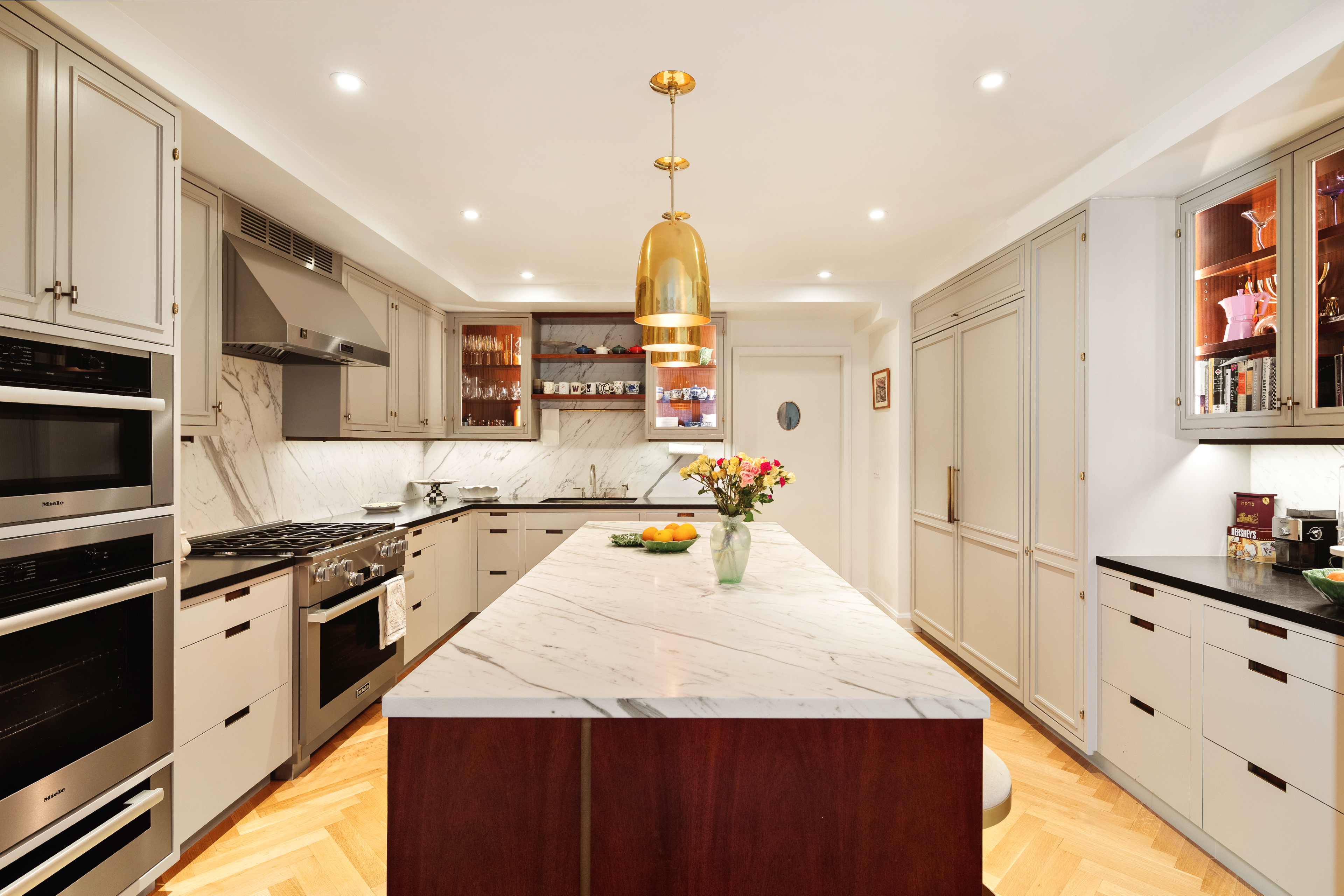 275 West 10th Street, Unit 3B Manhattan, NY 10014 - Photo 3 of 20 a kitchen with stainless steel appliances kitchen island granite countertop a refrigerator a stove a sink dishwasher and white cabinets with wooden floor