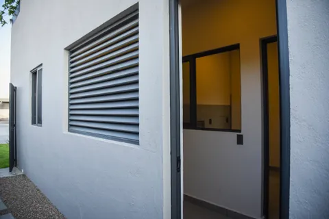 a view of an empty room with wooden floor and windows