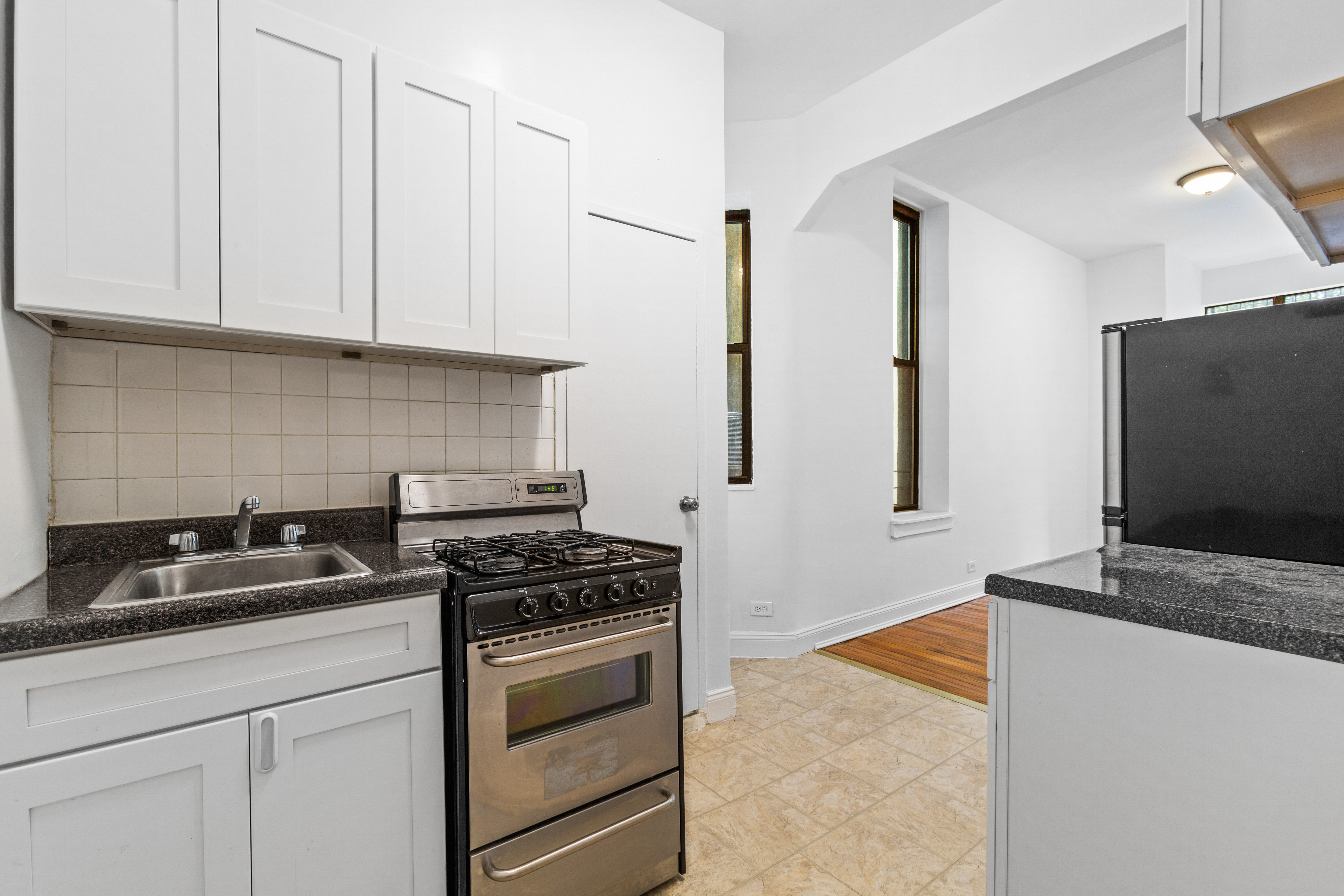 1775 Madison Avenue, Unit 1A Manhattan, NY 10035 - Photo 2 of 10 a kitchen with stainless steel appliances a stove a microwave and white cabinets