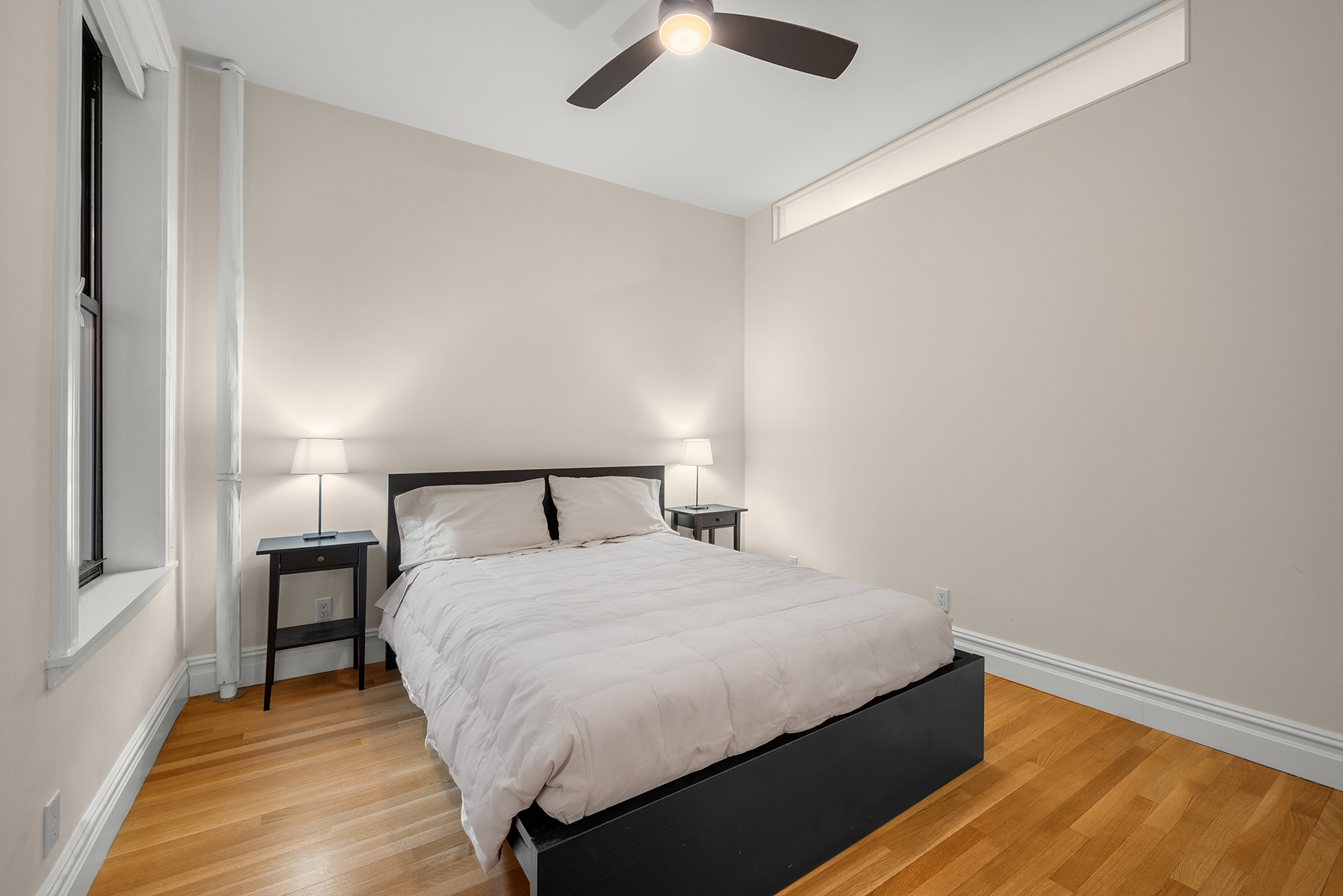 334 West 85th Street, Unit 3A Manhattan, NY 10024 - Photo 4 of 8 a large bed sitting in a bedroom next to a window and a chandelier