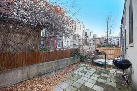 a view of a chairs and table in the back yard of the house