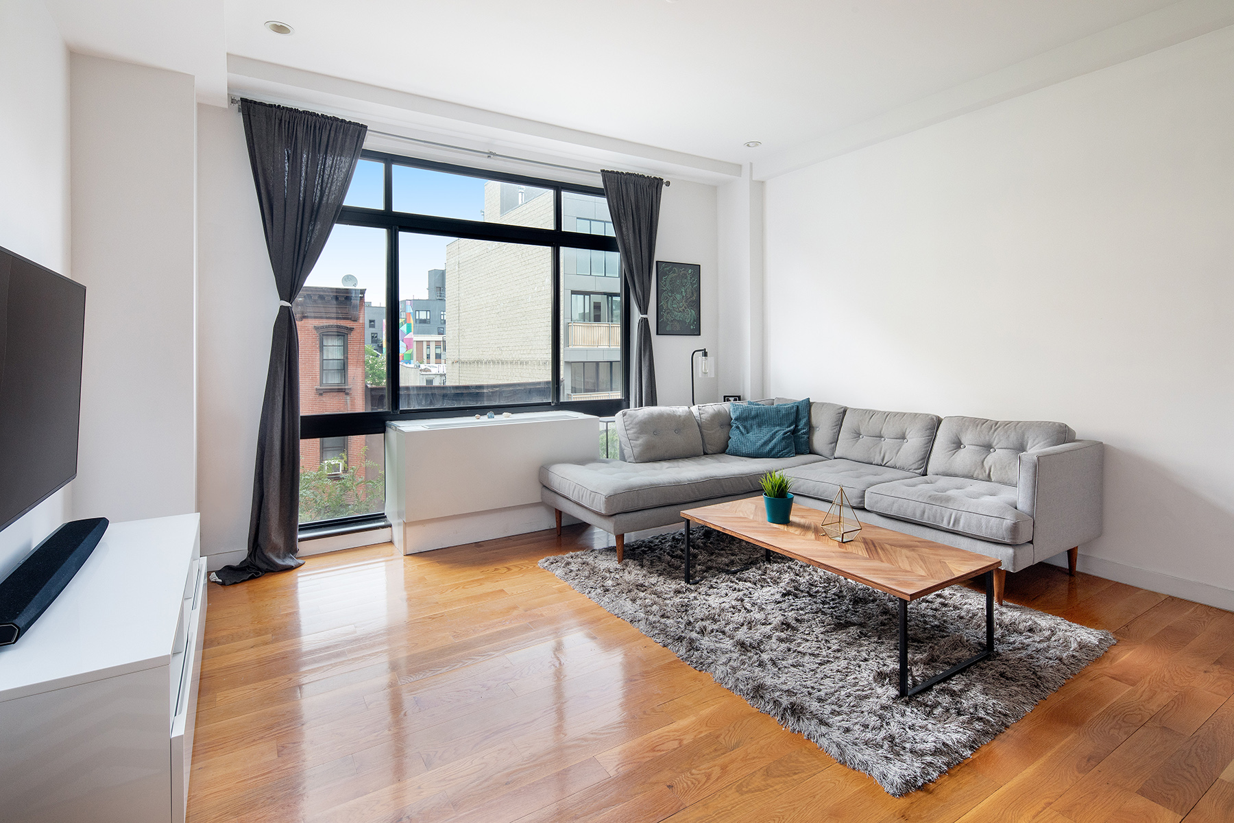 14 Hope Street, Unit 4D Brooklyn, NY 11211 - Photo 1 of 7 a living room with furniture and a floor to ceiling window