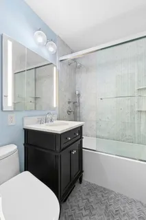 a bathroom with a sink vanity mirror and toilet