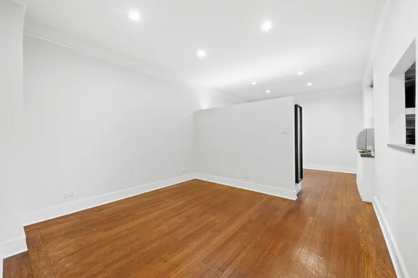 a view of empty room with wooden floor