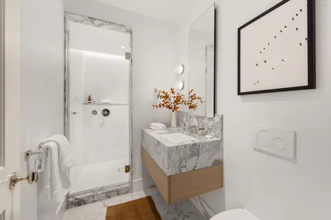 a bathroom with a granite countertop sink a toilet and shower