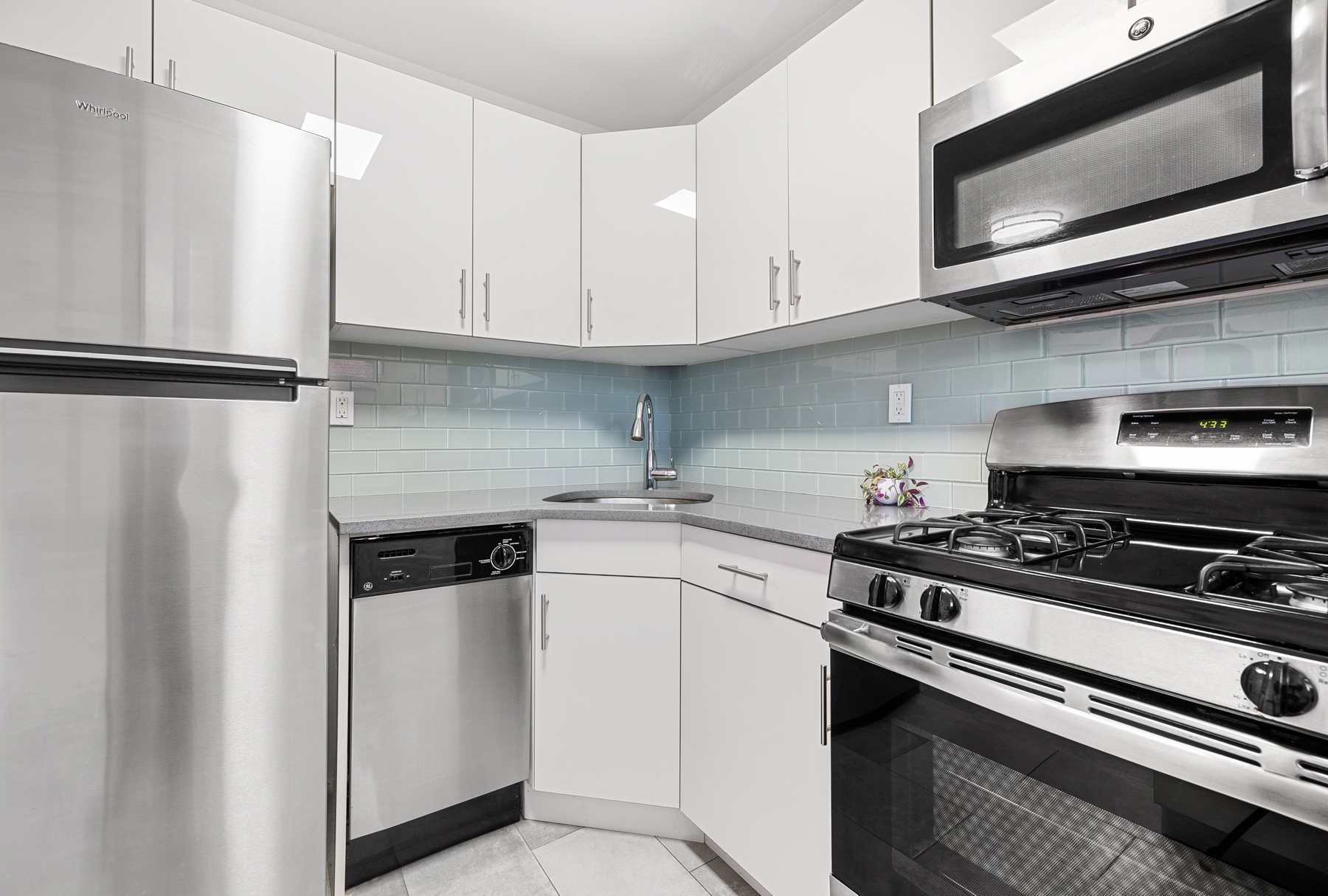 35-11 85th Street, Unit 4F Queens, NY 11372 - Photo 7 of 10 a kitchen with stainless steel appliances a stove a microwave and cabinets