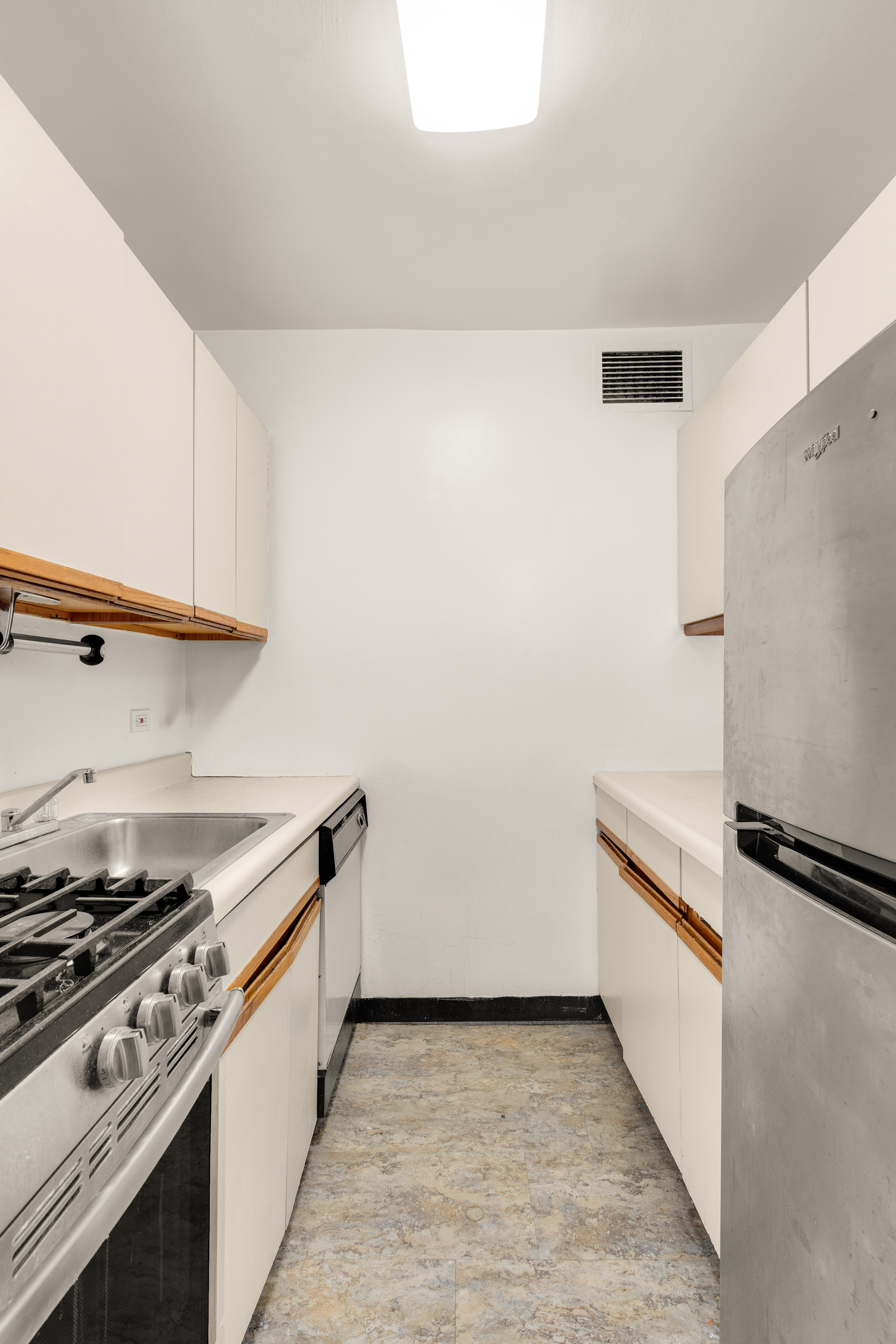 249 East 48th Street, Unit 12A Manhattan, NY 10017 - Photo 7 of 9 a kitchen with a stove and a refrigerator