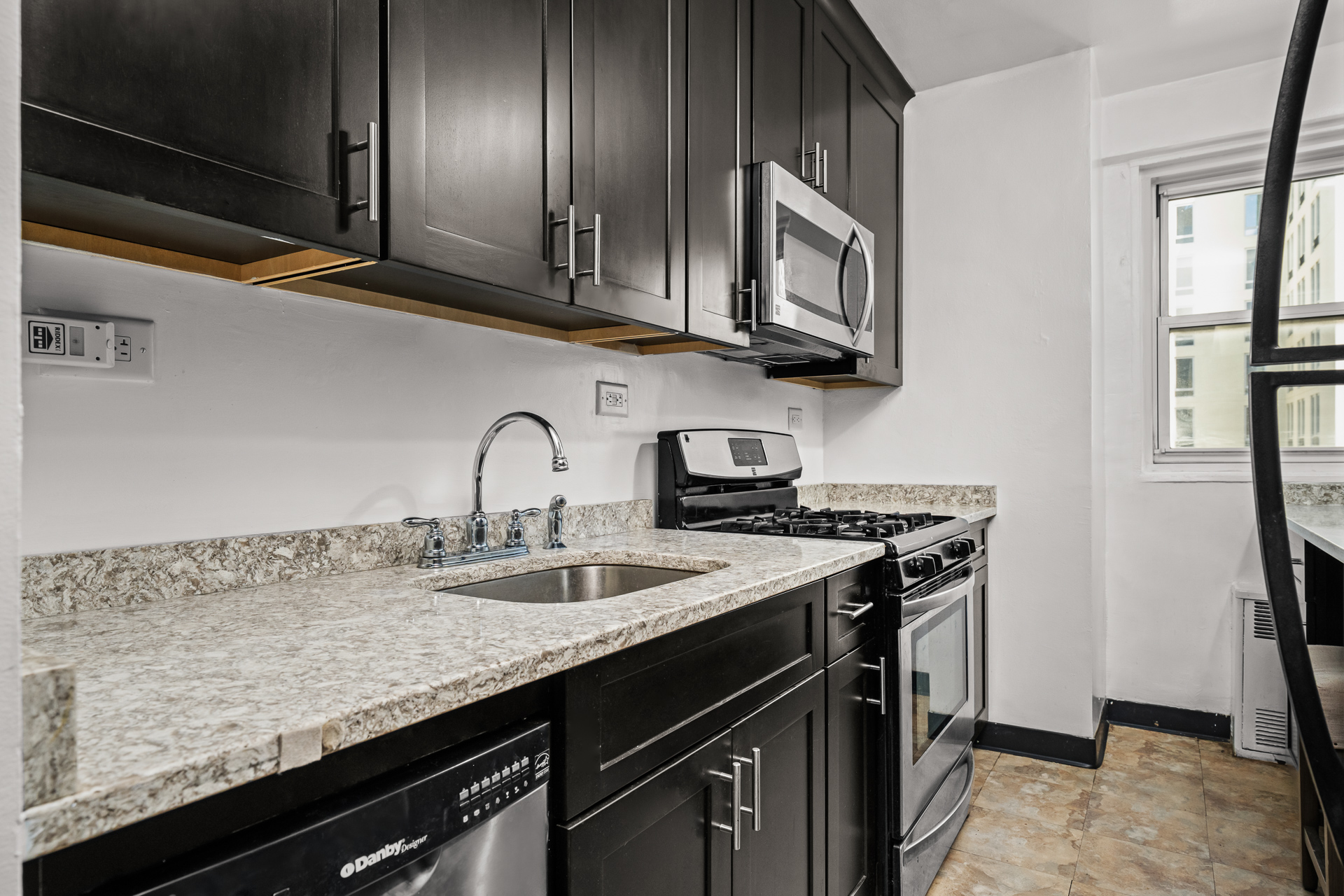 175 Willoughby Street, Unit 14N Brooklyn, NY 11201 - Photo 5 of 18 a kitchen with stainless steel appliances granite countertop a sink a stove and a microwave