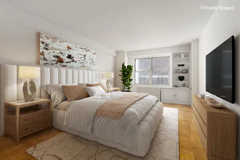 a bedroom with a large bed and a flat screen tv