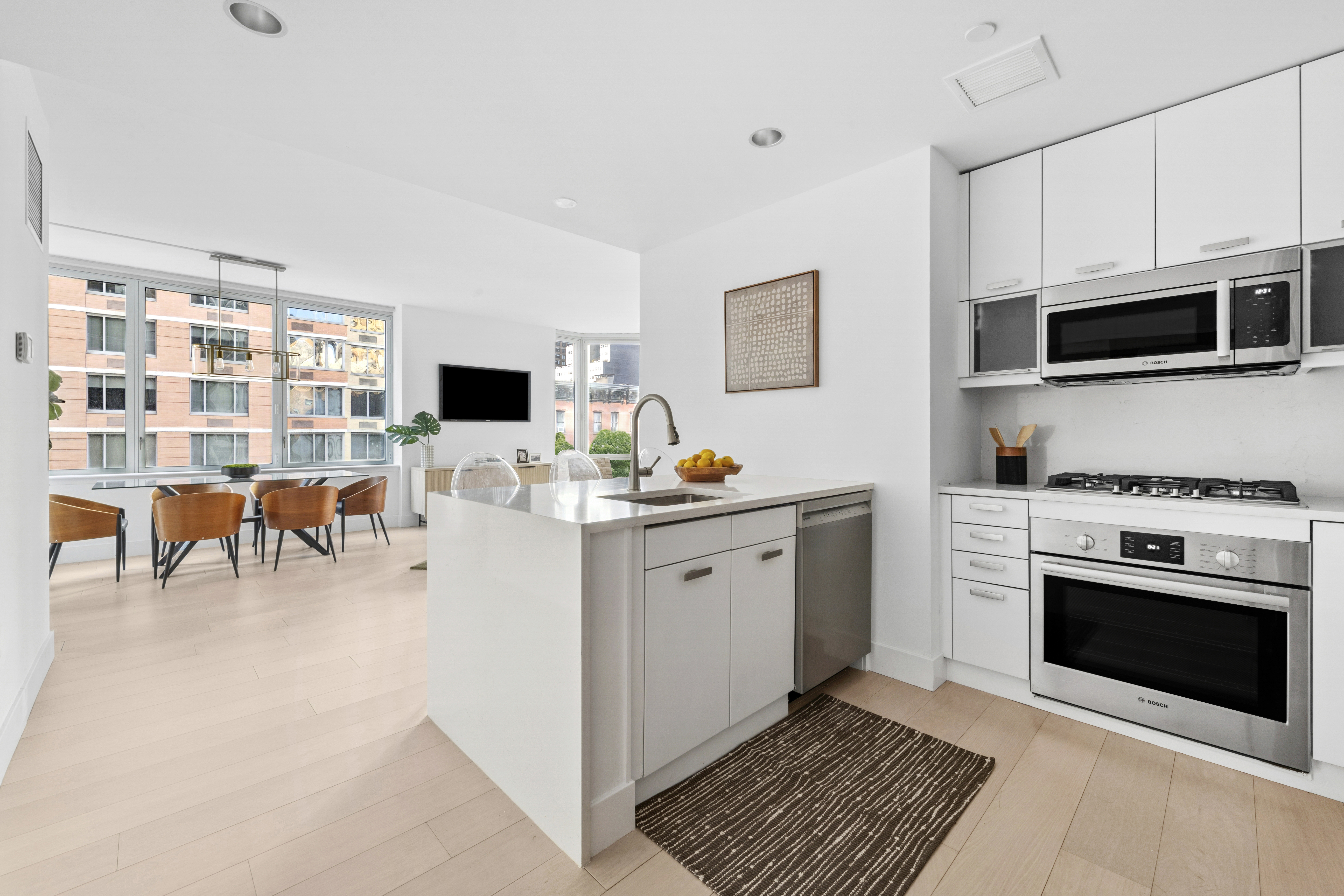 225 East 34th Street, Unit 5E Manhattan, NY 10016 - Photo 3 of 23 a kitchen with stainless steel appliances a stove microwave and cabinets