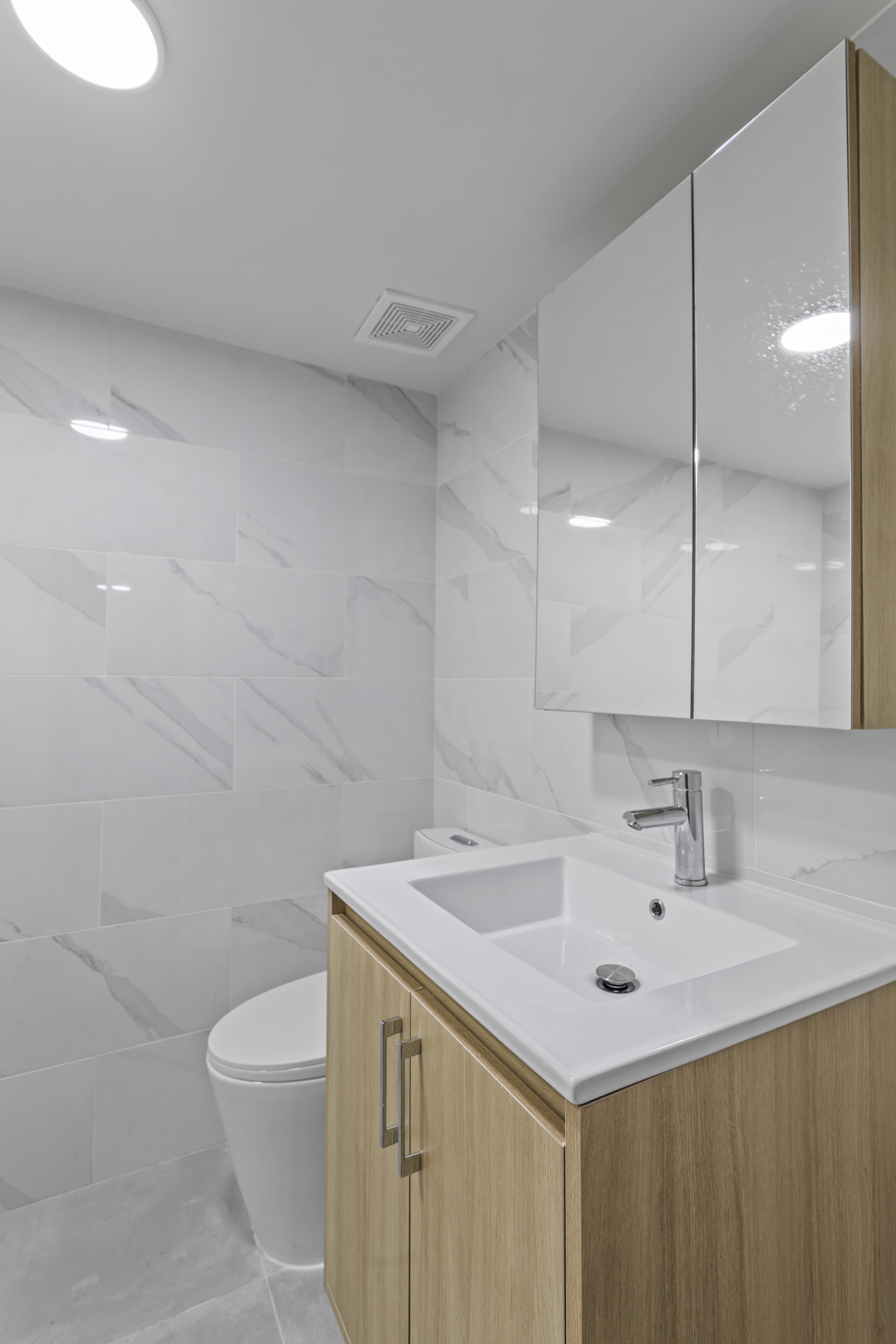 3112 Emmons Avenue, Unit 3124A2 Brooklyn, NY 11235 - Photo 13 of 17 a bathroom with a sink a toilet and a mirror