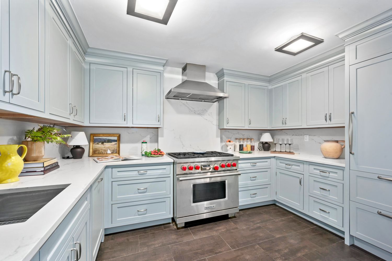 a kitchen with stainless steel appliances granite countertop a stove and white cabinets