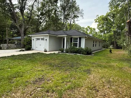 a front view of house with yard and trees