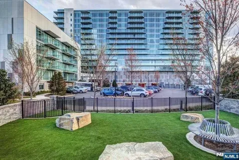 a front view of a building with garden and seating area