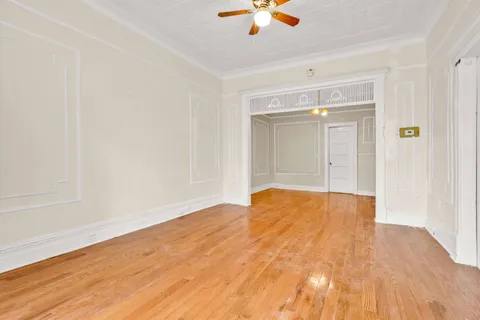 a view of a bedroom with wooden floor and a bathroom