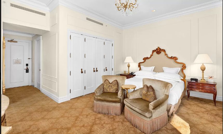 a spacious bedroom with a bed and a chandelier